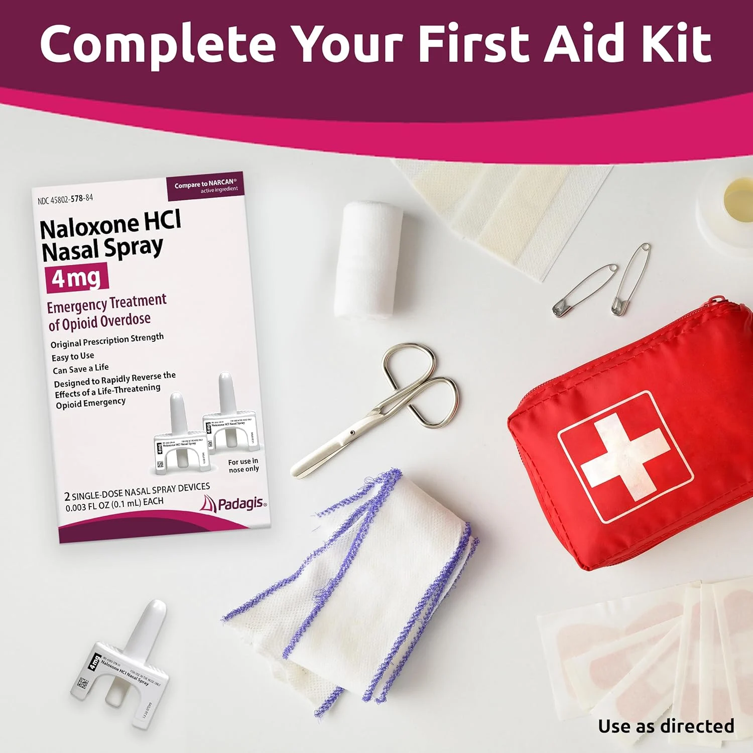 A first aid kit with medical supplies, including Naloxone HCl nasal spray, gauze, medical tape, safety pins, and a red pouch with a white cross symbol, arranged on a pink surface.